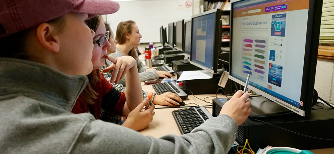 students pointing at computer screen