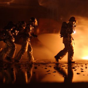 firefighters spraying a fire at night